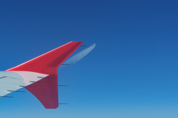 飞行中的飞机小翼和远处来袭的飞机的景象图片下载