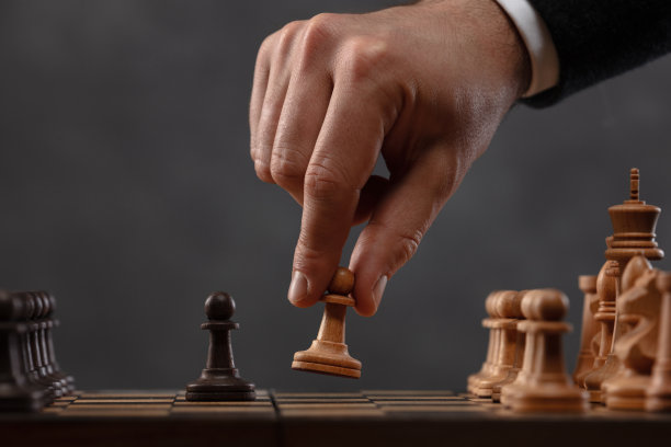 棋手将白兵向前移动。他的手和棋盘上的棋子。图片下载