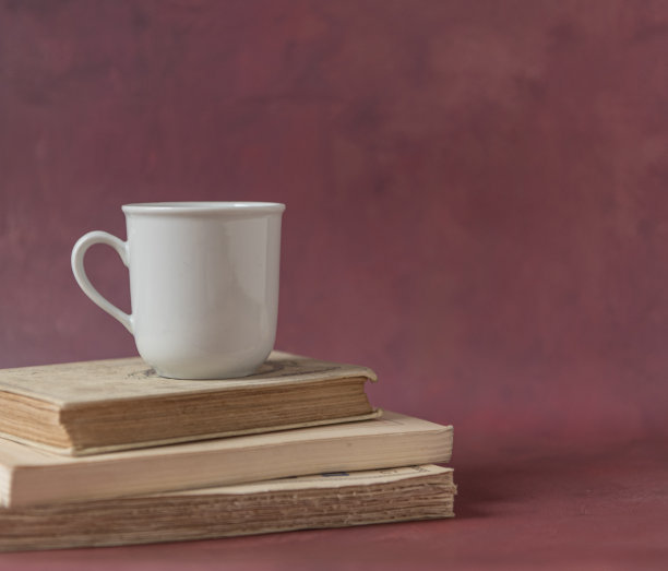 一堆旧书和一个红色背景的杯子图片下载