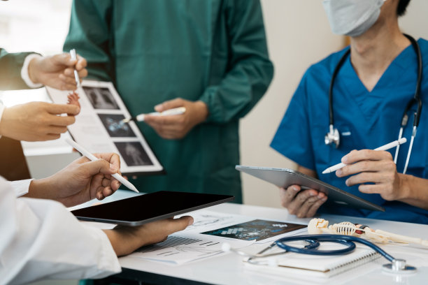 医疗团队致力于数字平板保健医生技术平板电脑，利用电脑对医院的医疗报告结果进行分析。图片下载