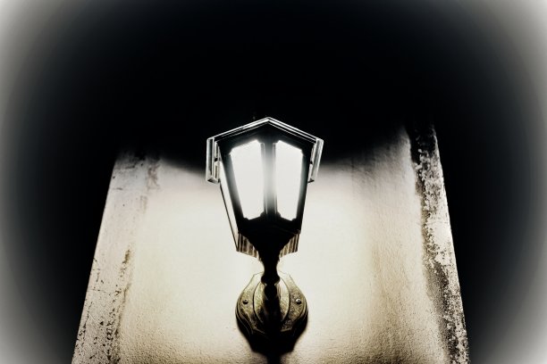 这幅图展示了一盏经典的柱灯在黑暗中以层层叠叠的光线发光。图片下载