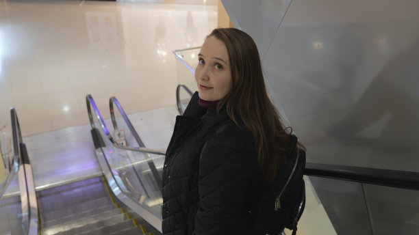 女孩下了自动扶梯。购物中心。购物的概念。自动扶梯向下移动。在商场购物图片下载