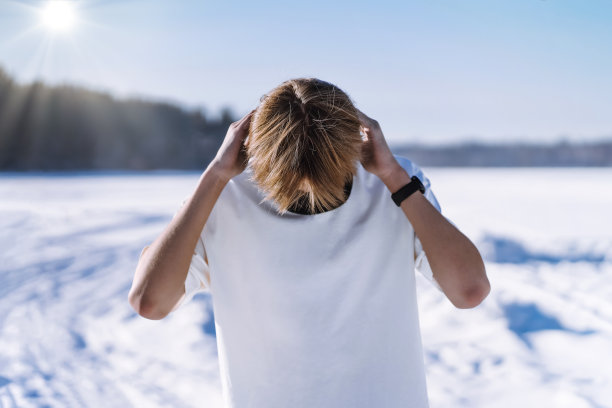 温暖。冬天，十几岁的孩子在雪地上脱下或穿上t恤图片下载