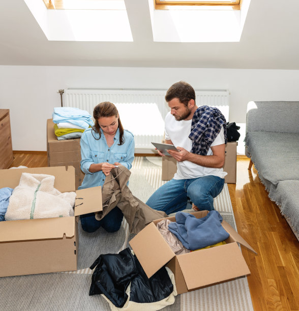 志愿者男女清点并打包衣物以供捐赠。图片下载