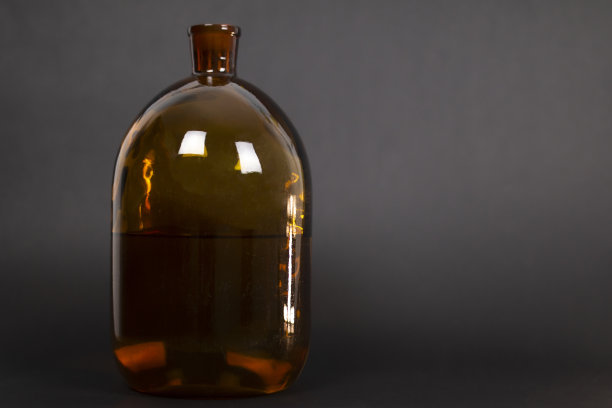 黑色背景上的棕色瓶子图片下载