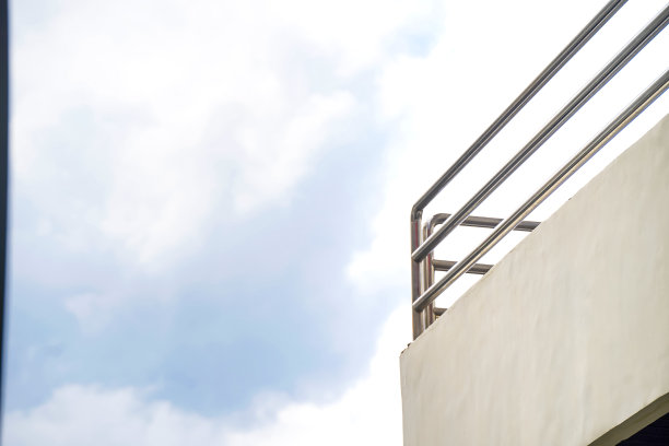 建筑二楼的栅栏，背景是多云的天空图片下载