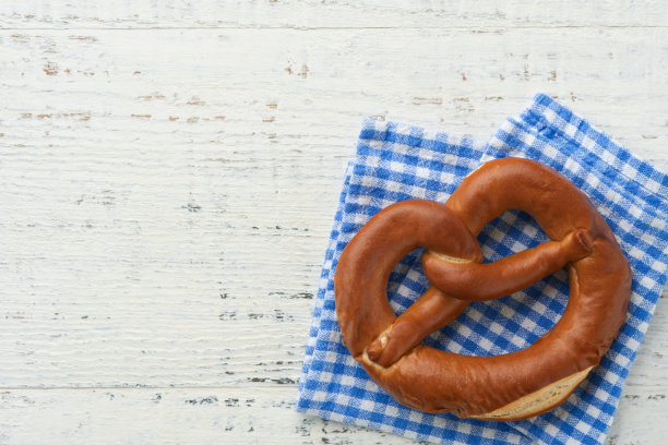 啤酒节概念卡。传统的巴伐利亚椒盐脆饼与啤酒瓶杯在老白色质朴的背景。非常适合十月节。啤酒节食物菜单。图片下载