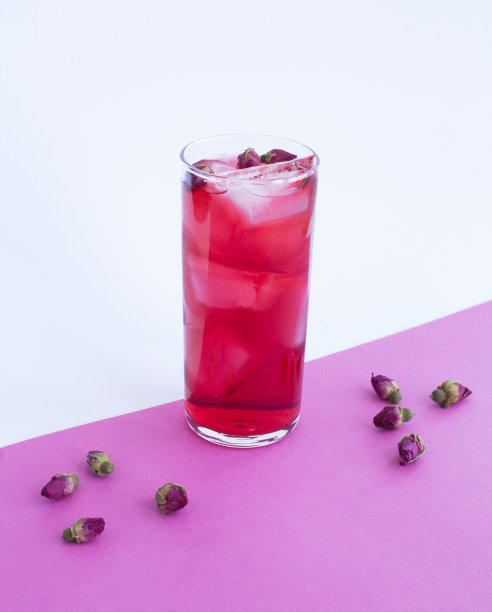 粉红色鸡尾酒加冰和玫瑰花在彩色背景的酒杯。特写镜头。图片下载