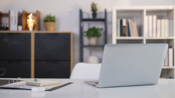 家庭办公室内部，笔记本电脑和文书在白色的桌子上。图片下载
