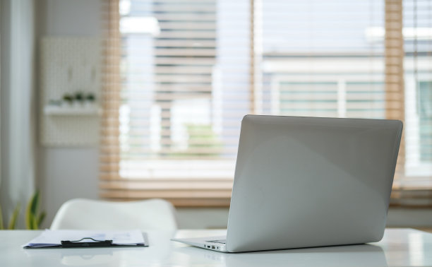 现代家庭办公室内部白色办公桌上的笔记本电脑和剪贴板。图片下载