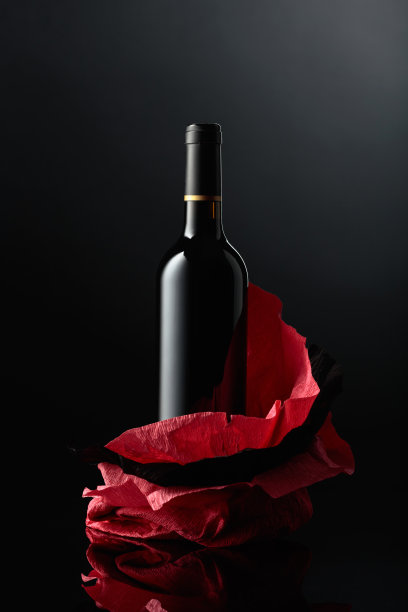 一瓶红酒放在皱巴巴的纸上。图片下载