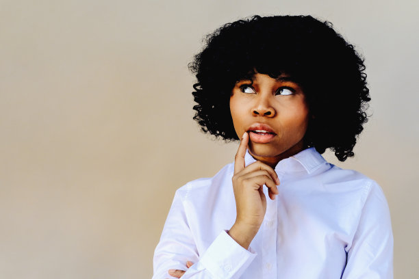 女人用手捂着下巴思考着，目光移开，望着拷贝空间图片下载