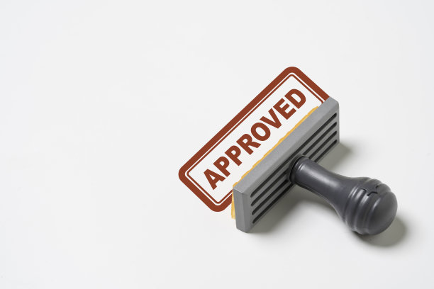 白色背景上的橡胶图章的红色文本批准的措辞，用于文件和项目通过考虑和质量控制ISO概念。图片下载