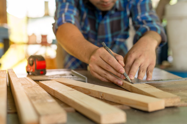 木匠正在用尺子和铅笔检查和标记要切割的点。业主一个小木材业务是加工家具生产。图片下载