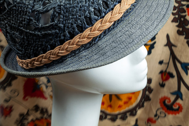 时尚店里，蓝色的夏日纸草帽戴在白色塑料假人头上图片下载