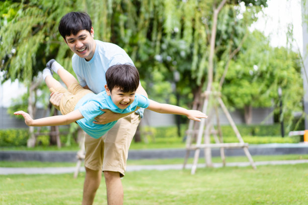 爸爸和儿子一起在操场上玩耍。图片下载