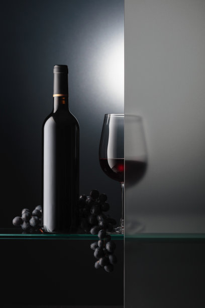 一瓶和一杯红酒，还有一串蓝葡萄。图片下载