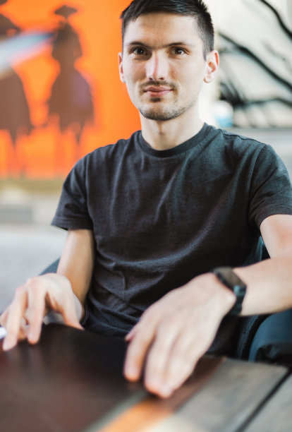 一个年轻人在餐馆里拿着一份纸质菜单。图片下载