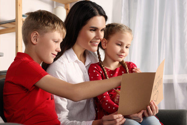 快乐的女人在家里收到孩子们寄来的贺卡图片下载