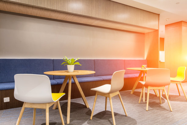 舒适的休息区，配有一些圆桌和椅子，晨光色调图片下载