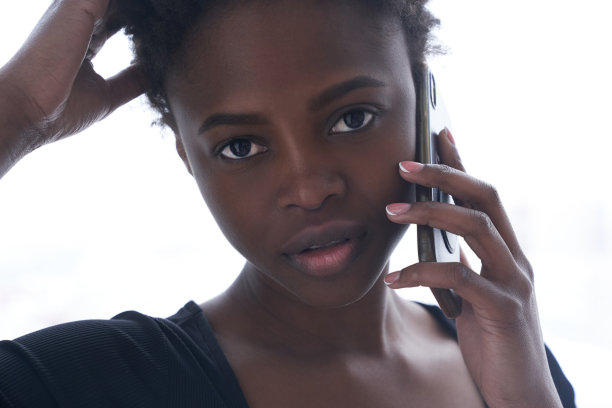 一个穿着运动服的年轻黑人妇女正在用手机看镜头。短发的年轻女子。特写生活方式照片与复制空间。高质量照片图片下载