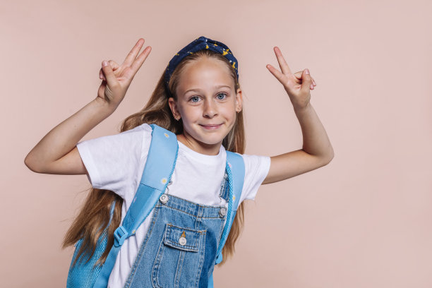 金发女学生用双手做和平胜利手势图片下载