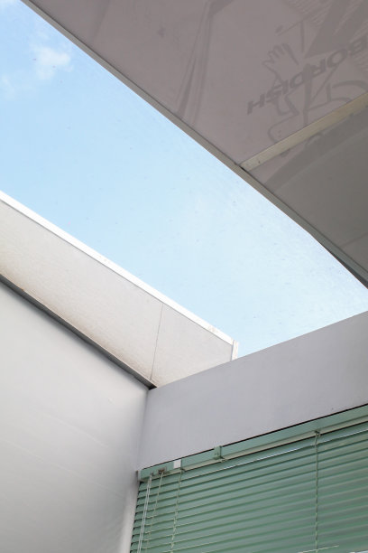 建筑一个玻璃屋顶天空与明亮的阳光。白色墙壁内部有大窗户。阳光明媚的日子穿过阳光灿烂的房子。图片下载