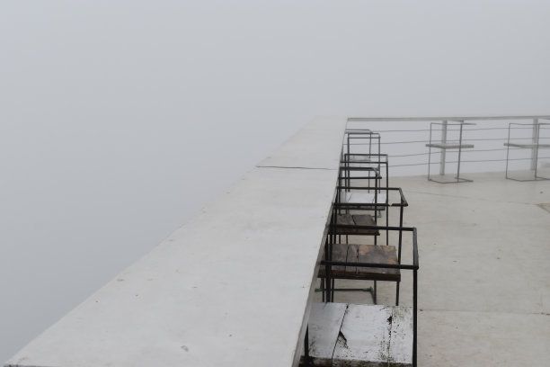 这张照片拍摄于印度尼西亚的一个山区，咖啡馆阳台上的一排长凳上弥漫着薄雾。图片下载