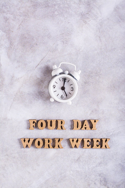 四天工作周的概念与木制字母和闹钟顶部和垂直视图图片下载