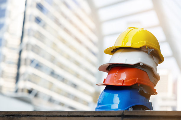 建筑工人，工程师，技术人员，在建筑工地工作的检查员的头盔。工作时戴上安全帽，防止事故发生。蓝领工人的工作设备-库存照片图片下载