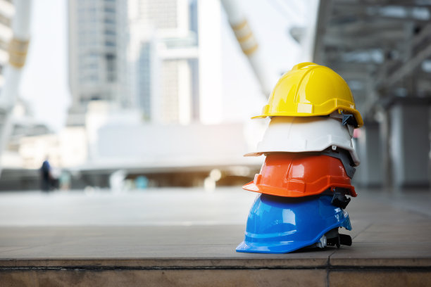 建筑工人，工程师，技术人员，在建筑工地工作的检查员的头盔。工作时戴上安全帽，防止事故发生。蓝领工人的工作设备-库存照片图片下载