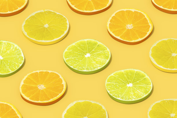柠檬和橙子水果片与阳光在黄色背景图片下载