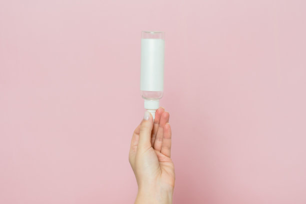 女人手里的化妆品瓶子。化妆品品牌模型。日常护肤和身体护理程序。图片下载