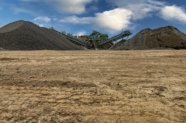 破碎机械，圆锥式岩石破碎机，在采石场露天采矿中输送破碎的花岗岩砾石。采矿行业采石输送机。图片下载