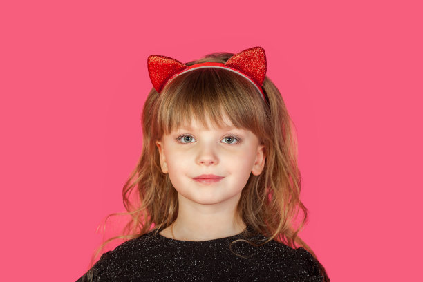 8-9岁的小女孩的特写肖像，在孤立的粉红色背景下，穿着黑色衣服，沉思地看着相机。可爱的孩子的脸在猫图像上的粉红色。时尚儿童概念。复制广告文本空间图片下载