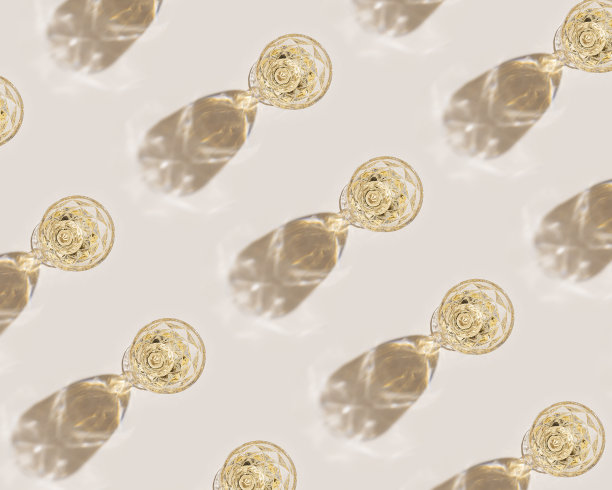 白葡萄酒装在晶莹透明的时尚玻璃杯里，搭配阳光，极简的潮流图案，浅米色背景，创意夏日休息酒饮概念，单色顶景，壁纸图片下载