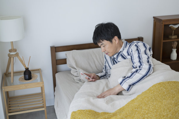 中年男子早上躺在床上看手机图片下载