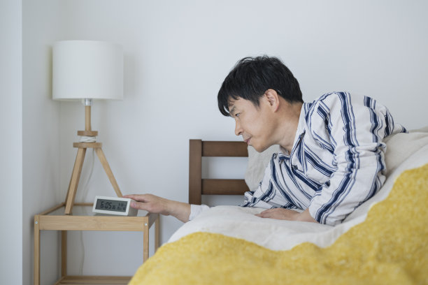 中年男子早上醒来，并停止闹钟图片下载