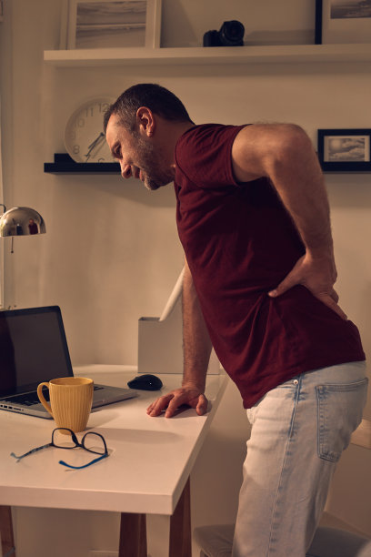 男人与臀部，背部，脊柱，疝和坐骨神经痛在家里。图片下载