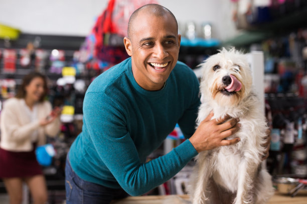 在宠物店里，感情用事的男人抱着狗图片下载
