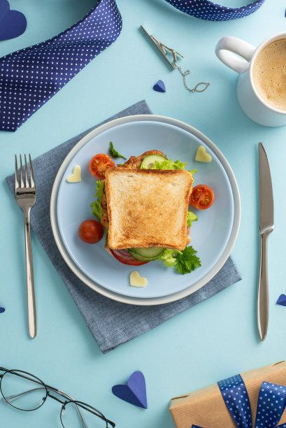 在父亲节这天，亲手做一顿早餐给父亲一个惊喜。俯视图垂直图片三明治与蔬菜，随着咖啡，餐具，和男人的配件在柔和的蓝色背景图片下载