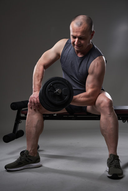 灰色背景上的成熟男子训练健身图片下载