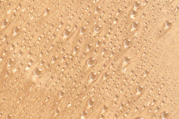 抽象化妆品的背景一滴润肤液在一个粉红色的背景。润肤水、化妆水、精华液。图片下载