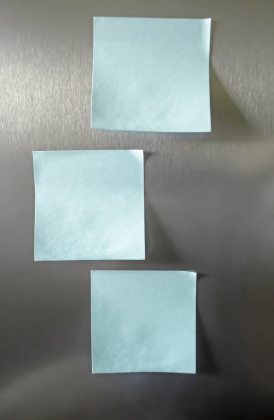 冰箱表面的蓝色纸条。金属背景上是录音用的蓝色贴纸。冰箱上的记录纸。图片下载