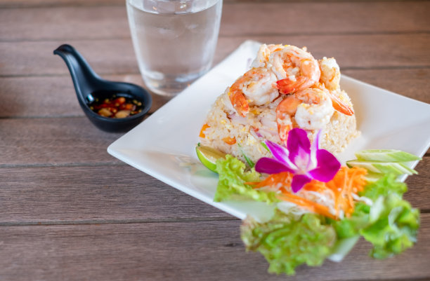 泰国菜，木桌上白色盘子上的虾炒饭图片下载