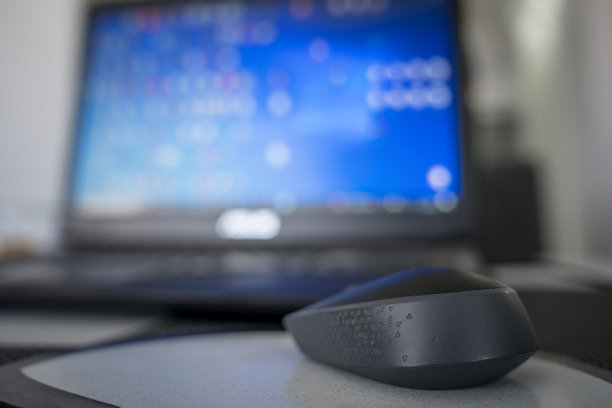 桌子上放着一台蓝色模糊屏幕的笔记本电脑。图片下载