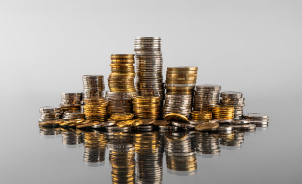 一堆堆硬币在灰色背景上的倒影图片下载