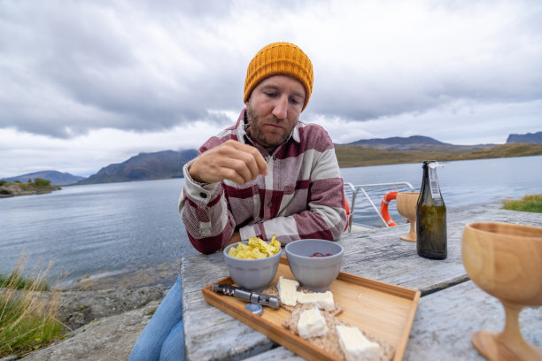 挪威，一个人在湖边吃小点心图片下载