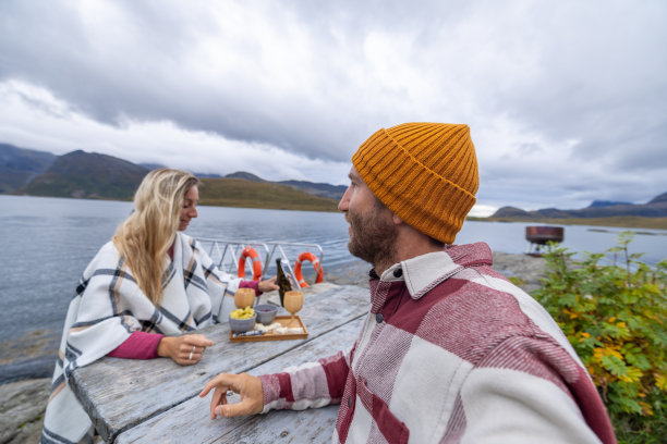 情侣在挪威湖边享用小吃图片下载