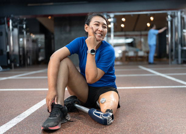 快乐的亚洲妇女与假腿锻炼在健身房或健身图片下载